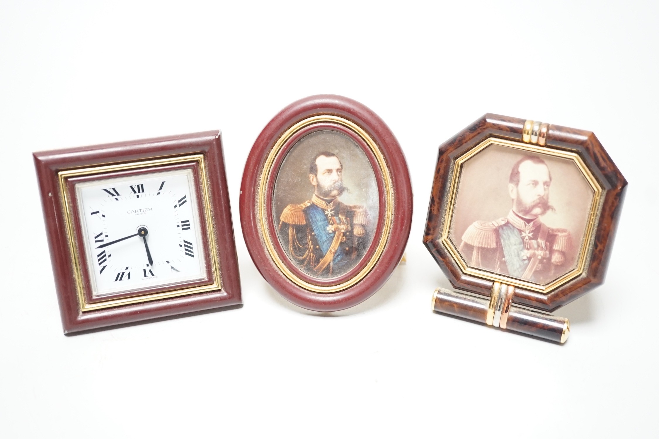 A Cartier travelling alarm timepiece and two Must de Cartier miniature frames